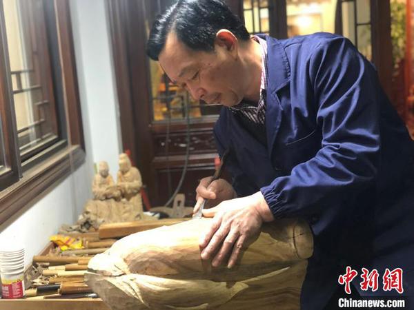 图为胡建华雕刻场景?！×植?摄