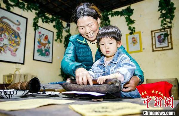 章亚红教孩子学习制作年画 张卉 摄 章亚红教孩子学习制作年画 张卉 摄