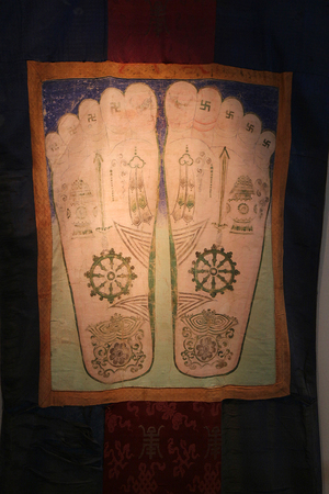 国际唐卡展区还展出了10幅文物级藏品唐卡，展示了精美绝伦的古代技艺。图为热贡艺术博物馆收藏的文物《清彩绘佛足图唐卡》