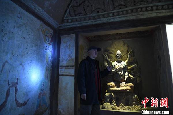 图为许林介绍洞窟壁画及佛头复原过程?！∥航ň?摄