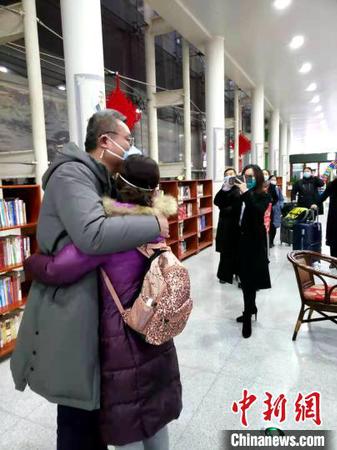 资料图：图为山东首批医疗队深夜集结支援武汉，医护人员出发前和家属拥抱告别?！∏窠?摄