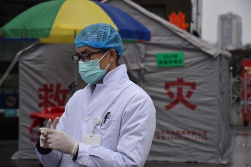 戴上一次性手套、一次性口罩、一次性帽子，穿着白大褂的谭晓鹏开始了一天的工作