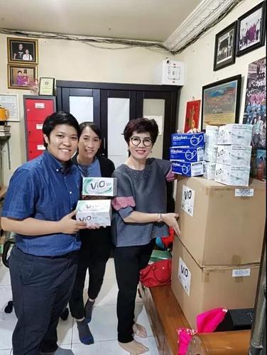 江春云（左）和蔡炜莉（中），在印尼巨港一家药店寻找医疗物资。