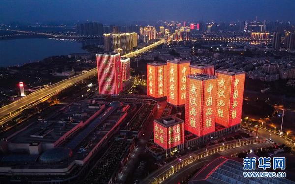 2月12日，武汉体育中心附近高层建筑外墙打出“武汉必胜”等字样（无人机照片）。 新华社记者 肖艺九 摄