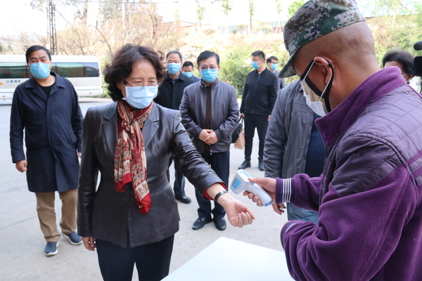 1：李江在云南东骏药业有限公司医药物流中心调研，测量体温