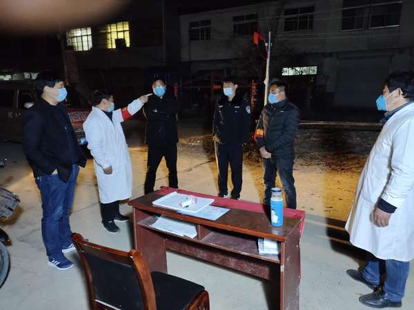 冯营乡党委副书记、乡长欧中锋（左一）到卡点查看夜间值班情况