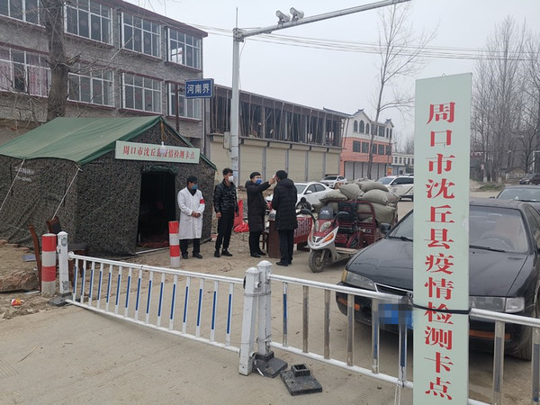 冯营乡天桥村省界卡点处，工作人员为群众测量体温