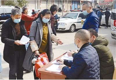 图为老肖夫妇出发前做好登记，准备乘车。