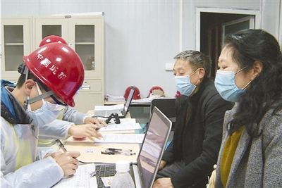 图为老肖夫妇到达工地后办理手续。