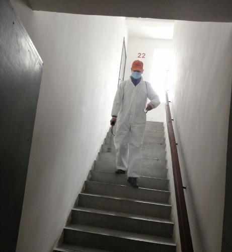 图为毛丽萍的丈夫在社区做志愿者，为楼栋消毒。