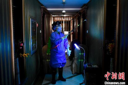 资料图。定点隔离酒店人员对酒店楼道进行消毒?！∥ち?摄
