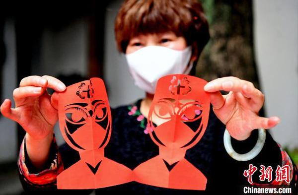 柘荣剪纸省级传承人吴秋凤现场演示创作“战疫”题材剪纸作品。　记者刘可耕 摄