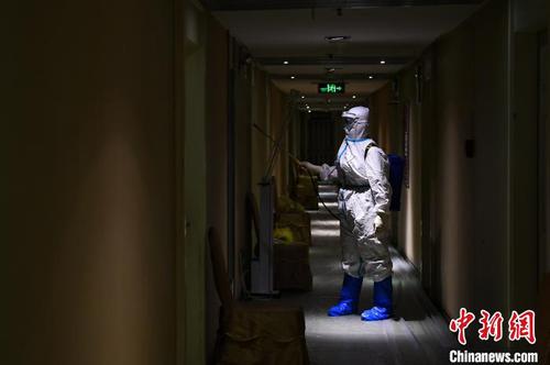 冯丕文穿着厚厚的防护服在酒店消毒?！∥淇〗?摄