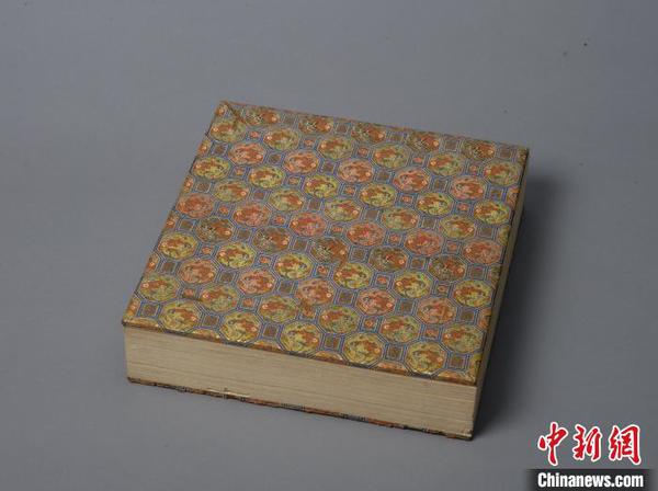 清宫旧藏《大乘喜金刚各佛秘密脉相图》。文物经板上裱有绫面，图案由六边形和方形组成，六边形中有龙纹，方形中为“万”和“寿”字。故宫出版社供图