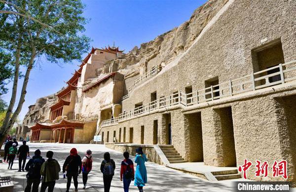 游客预约成功后，在采取了体温测量、佩戴口罩等防控措施后，有序进入敦煌莫高窟景区参观游览。　王斌银 摄