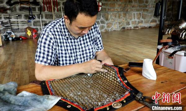 团队成员在修复铠甲。　刘恩权 摄