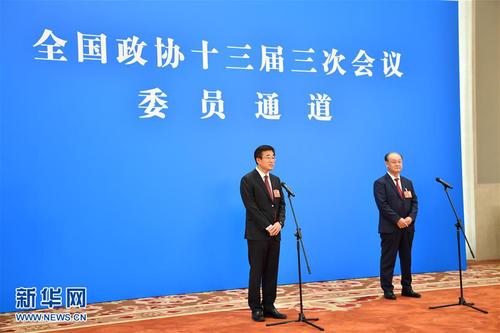 　5月21日，在北京人民大会堂新闻发布厅举行全国政协十三届三次会议第一场“委员通道”采访活动。这是全国政协委员王辰（左）和王阶通过网络视频方式接受媒体采访。 新华社记者李鑫摄