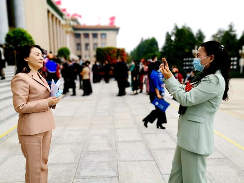 蓝天白云下，机场工作人员和会务组人员为福建省抵京委员导引路径。