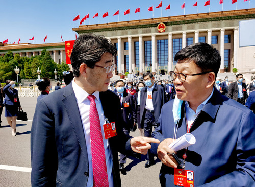 特邀委员记者韩方明（右）在天安门广场就国际疫情合作联防联控情况现场采访医药卫生界委员高福。 特邀委员记者 王众一 摄