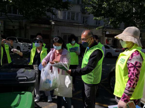 委员们帮助居民对垃圾进行分类投放 委员们帮助居民对垃圾进行分类投放