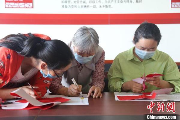 高彩霞传授剪纸的经验及技巧。　尤倩 摄