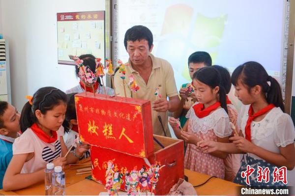 张明铁到学校为孩子们教授“妆糕人”制作技艺?！≌乓招?摄