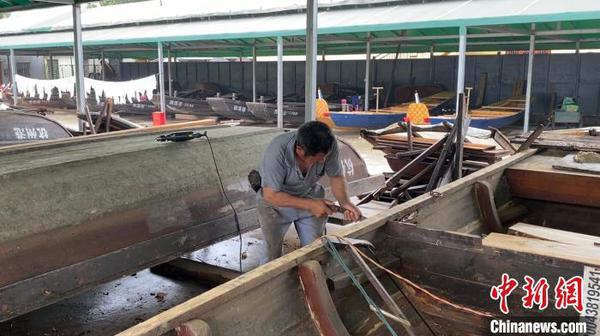 俞国炎正在维修破损船只。　钱晨菲 摄