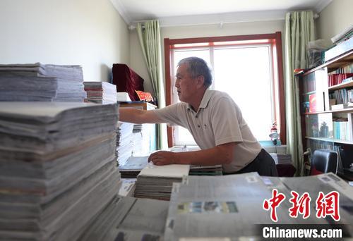 李竹庭正在他的“报库”中查找报纸?！∮诰?摄