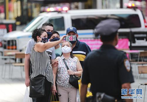 7月23日，人们戴着口罩在美国纽约时报广场拍照留念。 美国约翰斯·霍普金斯大学23日发布的新冠疫情最新统计数据显示，美国累计确诊病例超过400万例。数据显示，截至美国东部时间23日15时34分（北京时间24日3时34分），美国累计确诊病例4007859例，累计死亡病例143846例。 新华社记者 王迎 摄