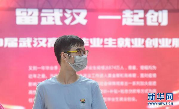 一名求职者在江汉大学校园内举办的招聘会现场寻找合适的岗位（6月1日摄）。这是疫情发生后，武汉举办的首场高校毕业生专场线下招聘会。 新华社记者 程敏 摄