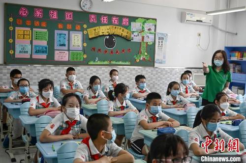 资料图：小学生佩戴口罩返校复课。　张兴龙 摄