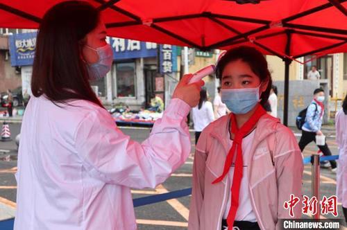 资料图：一学生测温进校园 苍雁 摄
