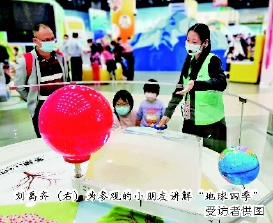刘禹齐（右）为参观的小朋友讲解“地球四季”　 受访者供图
