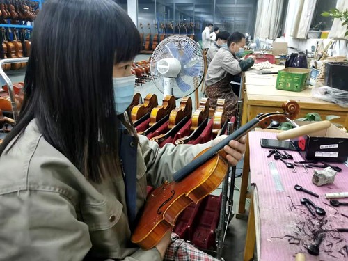 焦继丽在检查小提琴刮板工序。人民政协网记者付振强 摄