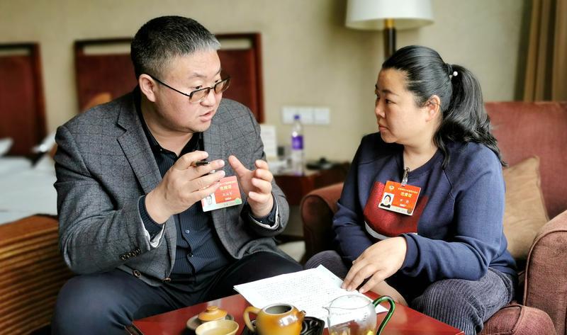 青联界马海军委员（左）与田静委员在一起讨论提案。 特约委员记者 马全林摄
