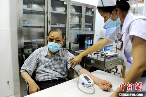 医护人员为大陆知名台商李瑞河(左)做接种前的检查?！≌沤鸫?摄