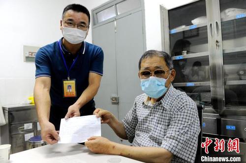 旧镇卫生院相关负责人把盖好章的预防接种凭证递给大陆知名台商李瑞河(右)。　张金川 摄