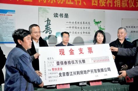 2018 年，吴来盛（左二）与杨莉珊（左四）为天津市武清区河北屯镇的东苏庄村、西 楼村捐款实施自来水管网提升建造工程