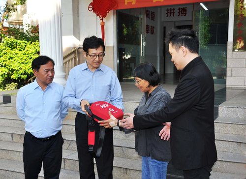 二○二三年九月二十三日，孙达率“红心闪闪”项目办成员前往云南省丽江市华坪女子高级中学进行捐赠。图为孙达（左二）向张桂梅（右二）介绍AED。 （图片由受访者提供）