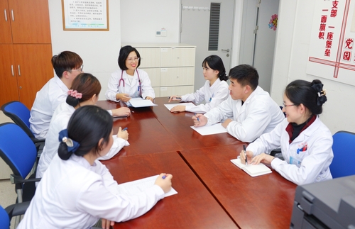 毛莉（居中）与同事们一起讨论工作。（图片由受访者提供）