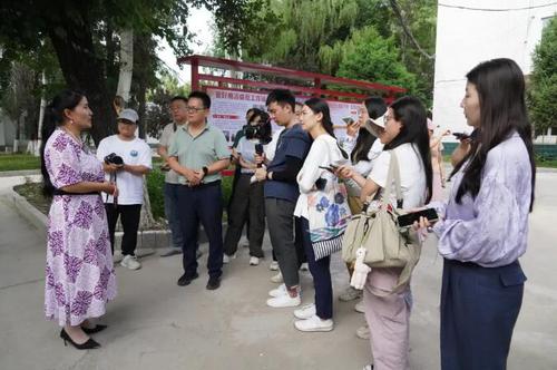 △在新源县喀拉布拉镇，贾娜尔委员（左一）接受记者采访。