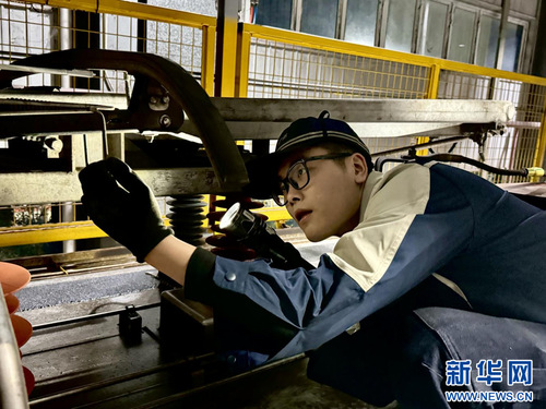 广州东动车运用所检修班组长丁帅检查动车组高压设备。新华网发 （谢荣浩 摄）