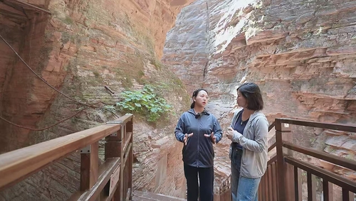 在“瓮圪廊”大峡谷，冯芬芬委员（左）向记者讲述崔振芳烈士的故事。