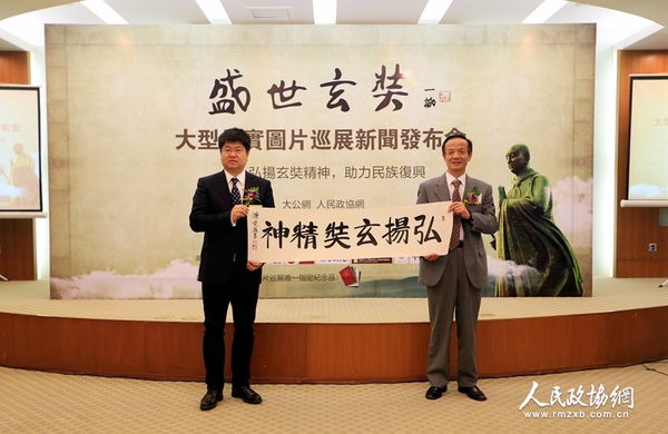 中国佛教协会常务理事陈星桥与大公报社长助理、北京分社社长、大公网执行总裁兼总编辑王文韬展示中国佛教协会驻会副会长演觉法师的墨宝——《弘扬玄奘精神》（摄影：姚勇）
