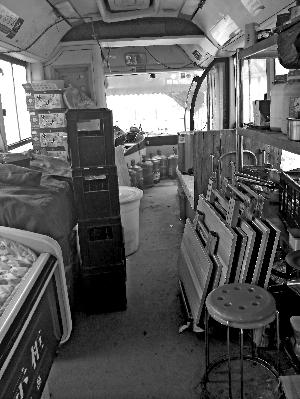 公交车内的座椅被拆除，放了冰柜、餐桌、货架。