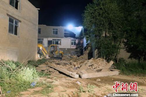 图为一台挖掘设备正在对事发现场进行清理 胡贵龙 摄