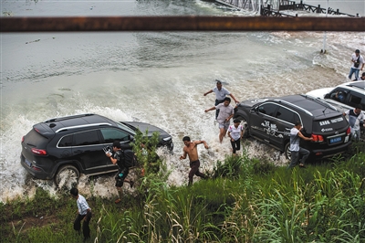 昨日，梁子湖与牛山湖隔堤正式实施爆破作业，完成分洪，人们躲避爆破后激起的余浪。新华社记者 肖艺九 摄