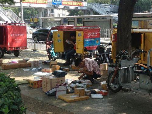 2016年8月2日，北京。多家快递公司的快递员在办公楼下通知、等待收件人下楼取件。中国网 魏婧 摄